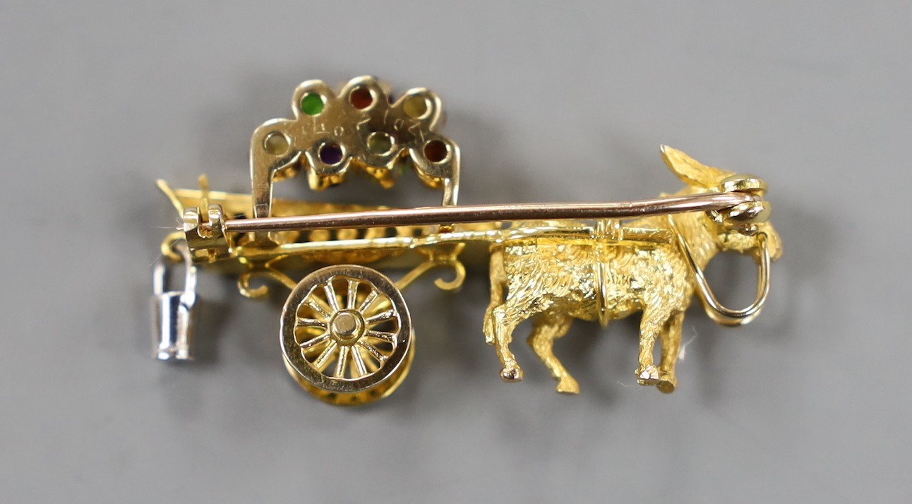 A modern yellow metal hinged bangle with Greek Key decoration and a 9ct donkey and cart charm, gross weight 23.2 grams.